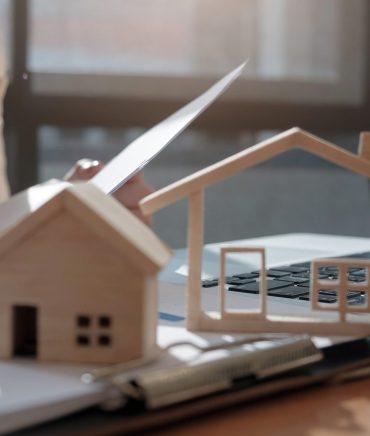A real estate agent with House model is talking to clients about akinhth periousia