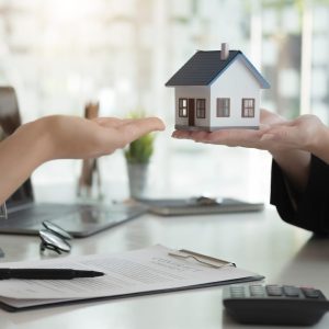 Sale representative offer house purchase contract to buy a house or apartment or discussing about loans and interest rates